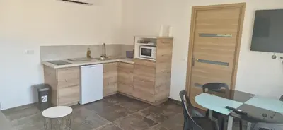a small kitchen with a table and a microwave at Maison a Porto Pollo Corse du sud in Serra-di-Ferro