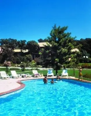 a swimming pool with chairs and people in it at un oasi nel verde in Vaccili