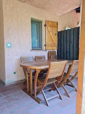 a wooden table and chairs on a patio at un oasi nel verde in Vaccili