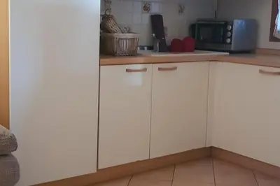 a kitchen with white cabinets and a microwave at un oasi nel verde in Vaccili