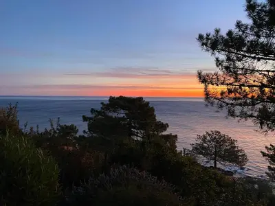 a sunset over the ocean with trees on a hill at Villa Tarco, South Corsica, Sea View & Garden in Conca