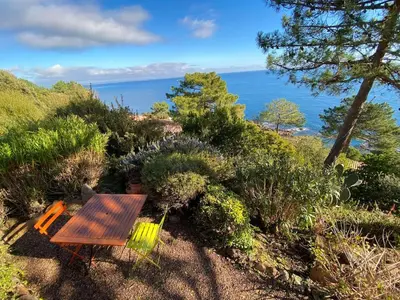 a wooden table and chairs sitting on top of a hill at Villa Tarco, South Corsica, Sea View & Garden in Conca