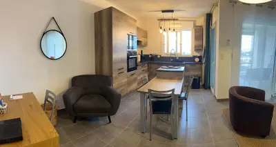a kitchen and living room with a table and chairs at Appartement T2 50 m2 Ricanto à AJACCIO in Ajaccio
