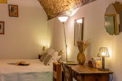 a bedroom with a bed and a table and a mirror at Casa U Quercitellu Ville-di-Paraso in Ville-di-Paraso