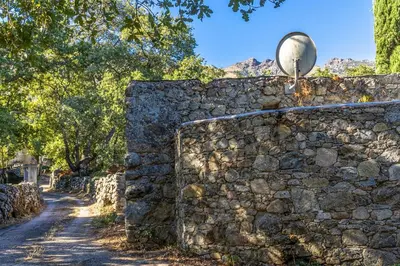 an old stone wall with a satellite dish on top at Casa U Quercitellu Ville-di-Paraso in Ville-di-Paraso