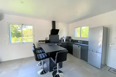 a kitchen with a counter and some chairs in it at Villa Oliu Di Santa Lucia in Conca