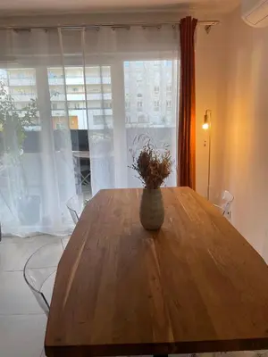 a wooden table with a vase on top of it at Charming Apartment Ajaccio in Ajaccio
