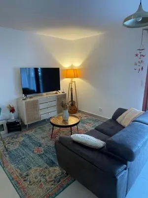 a living room with a blue couch and a table at Charming Apartment Ajaccio in Ajaccio