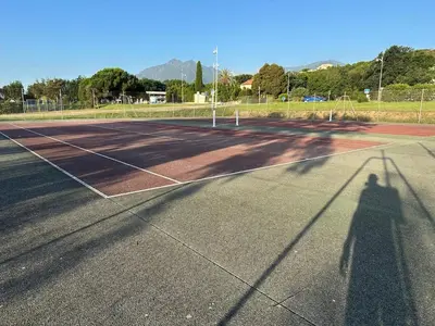 a shadow of a person on a tennis court at Maisonnette privé bord de mer Poggio mezzana in Poggio-Mezzana