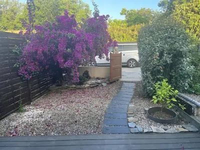 a garden with purple flowers and a fence at Maisonnette privé bord de mer Poggio mezzana in Poggio-Mezzana