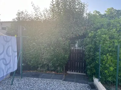a fence with a gate in front of a bush at Maisonnette privé bord de mer Poggio mezzana in Poggio-Mezzana