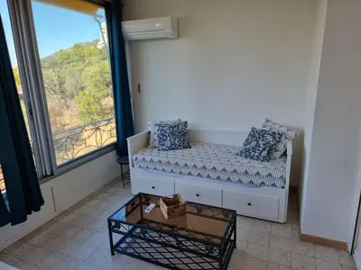 a living room with a couch and a large window at Résidence des îles - Samos III in Ajaccio