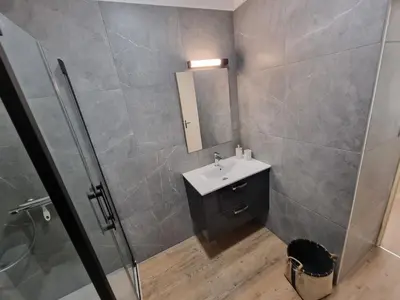 a bathroom with a sink and a shower with a mirror at Résidence des îles - Samos III in Ajaccio