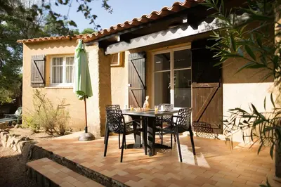 a patio with a table and chairs and an umbrella at Villa Lavezzi F2 2-4 pers Rondinara, Bonifacio in Bonifacio
