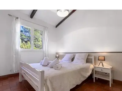 a bedroom with a white bed with a window at Villa Lavezzi F2 2-4 pers Rondinara, Bonifacio in Bonifacio