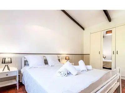 a white bedroom with a large bed with white pillows at Villa Lavezzi F2 2-4 pers Rondinara, Bonifacio in Bonifacio