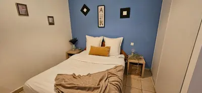 a small bedroom with a bed with a blue wall at T2 Alba Rossa n 124, Chaleureux vue mer et piscine in Serra-di-Ferro