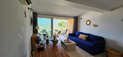a living room with a blue couch and a table at T2 Alba Rossa n 124, Chaleureux vue mer et piscine in Serra-di-Ferro