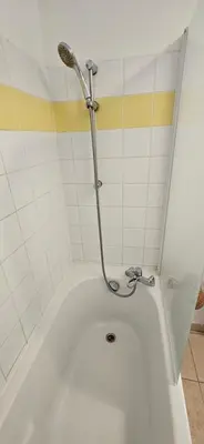 a bath tub with a shower in a bathroom at T2 Alba Rossa n 124, Chaleureux vue mer et piscine in Serra-di-Ferro