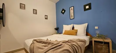 a bedroom with a bed with a blue wall at T2 Alba Rossa n 124, Chaleureux vue mer et piscine in Serra-di-Ferro