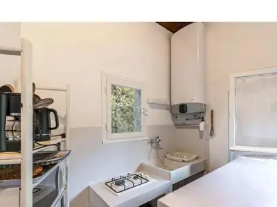 a white kitchen with a stove and a window at Villa RoccaPina 35 m2 - 2 - 4 people Rondinara, Bonifacio in Bonifacio