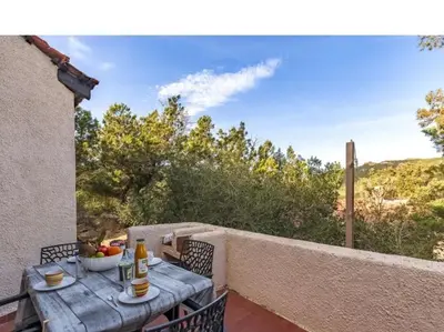 a table and chairs on the balcony of a house at Villa RoccaPina 35 m2 - 2 - 4 people Rondinara, Bonifacio in Bonifacio