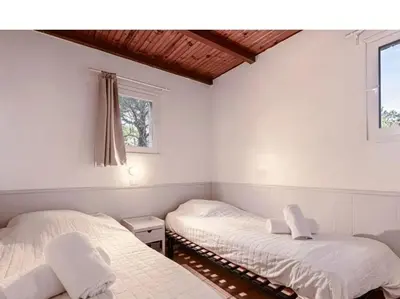 two beds in a room with two windows at Villa Cala Rossa 45M2 4-5 pers Rondinara Bonifacio in Bonifacio