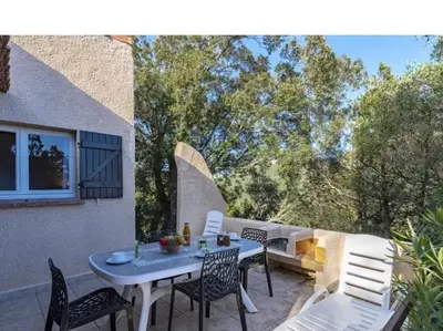 a patio with a table and chairs and a bench at Villa Cala Rossa 45M2 4-5 pers Rondinara Bonifacio in Bonifacio