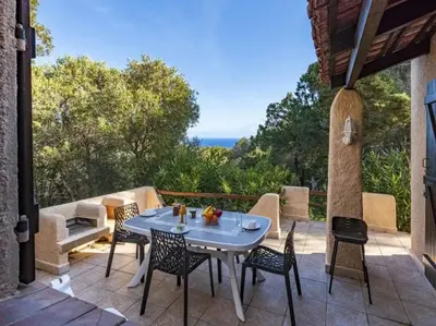 a table and chairs on a patio with a view at Villa Cala Rossa 45M2 4-5 pers Rondinara Bonifacio in Bonifacio