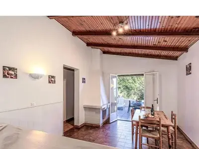 a kitchen and dining room with a table and chairs at Villa Cala Rossa 45M2 4-5 pers Rondinara Bonifacio in Bonifacio
