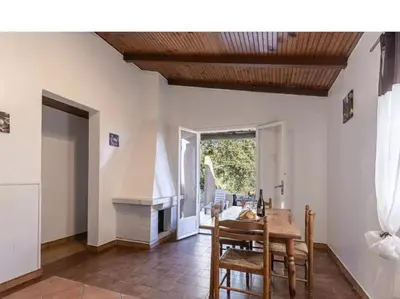 a dining room with a table and a fireplace at Villa Cala Rossa 45M2 4-5 pers Rondinara Bonifacio in Bonifacio