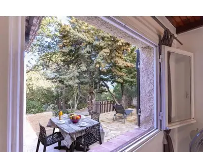 a patio with a table and chairs and a window at Villa Folaca 45m2 5 pers Rondinara Bonifacio in Bonifacio