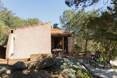 a small building with a table and chairs in front of it at Villa Folaca 45m2 5 pers Rondinara Bonifacio in Bonifacio