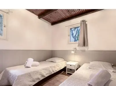 two twin beds in a room with a window at Villa Folaca 45m2 5 pers Rondinara Bonifacio in Bonifacio