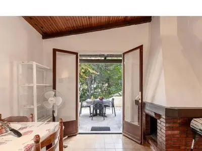 a living room with a fireplace and a dining room at Villa Folaca 45m2 5 pers Rondinara Bonifacio in Bonifacio