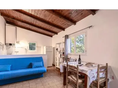 a living room with a blue couch and a table at Villa Folaca 45m2 5 pers Rondinara Bonifacio in Bonifacio