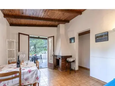a living room with a table and a dining room at Villa Folaca 45m2 5 pers Rondinara Bonifacio in Bonifacio
