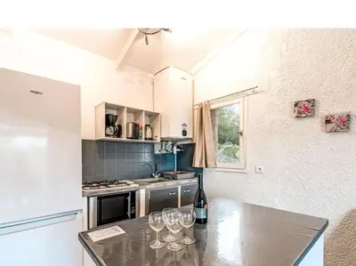 a kitchen with wine glasses on a table at Villa 65m2 7 pers - Rondinara, Bonifacio in Bonifacio