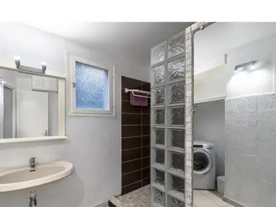 a bathroom with a sink and a washing machine at Villa 65m2 7 pers - Rondinara, Bonifacio in Bonifacio