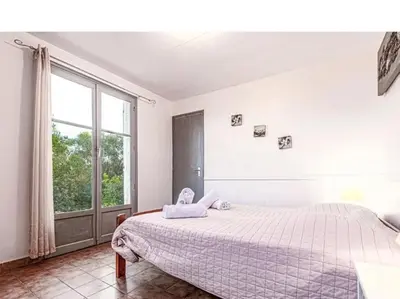 a bedroom with a bed and a large window at Villa 65m2 7 pers - Rondinara, Bonifacio in Bonifacio