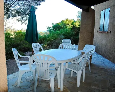 a white table and chairs and a green umbrella at Villa 65m2 7 pers - Rondinara, Bonifacio in Bonifacio