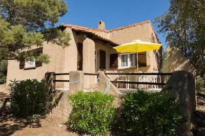 a house with a yellow umbrella in front of it at Villa Balistra 45 m2 5 pers Rondinara Bonifacio in Bonifacio