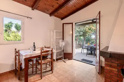 a dining room with a table and a door to a patio at Villa Balistra 45 m2 5 pers Rondinara Bonifacio in Bonifacio