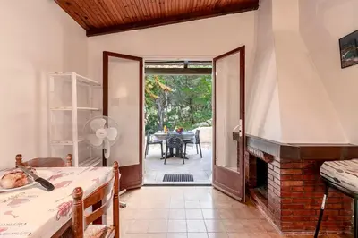 a room with a fireplace and a room with a table at Villa Balistra 45 m2 5 pers Rondinara Bonifacio in Bonifacio
