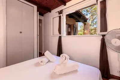 a bedroom with two towels on a bed with a window at Villa Balistra 45 m2 5 pers Rondinara Bonifacio in Bonifacio