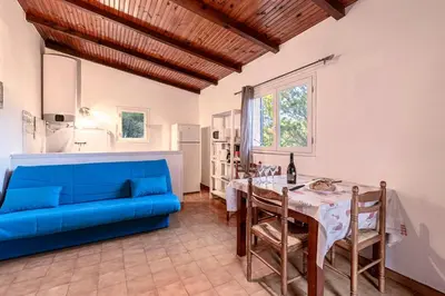 a living room with a blue couch and a table at Villa Balistra 45 m2 5 pers Rondinara Bonifacio in Bonifacio
