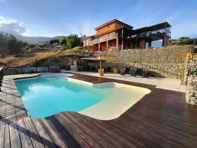 a house with a swimming pool and a wooden deck at JARDIN de PRATAVONE in Cognocoli-Monticchi
