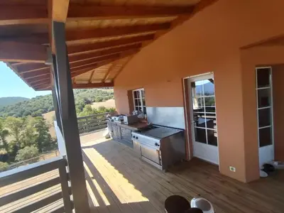 a kitchen with a deck with a view of the mountains at JARDIN de PRATAVONE in Cognocoli-Monticchi