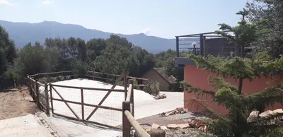 a view of a house with mountains in the background at JARDIN de PRATAVONE in Cognocoli-Monticchi