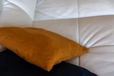 a brown pillow sitting on top of a white couch at Les Hameaux De Buttaciolo in Cuo